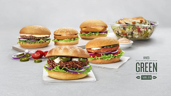 Fem forskellige burgere og en salat på et gråt bord.