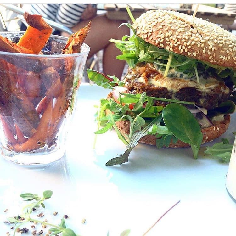 Burger med sesambolle, salat og søde kartoffel fritter.