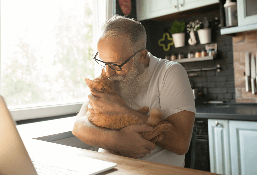 Ældre mand sidder med sin kat
