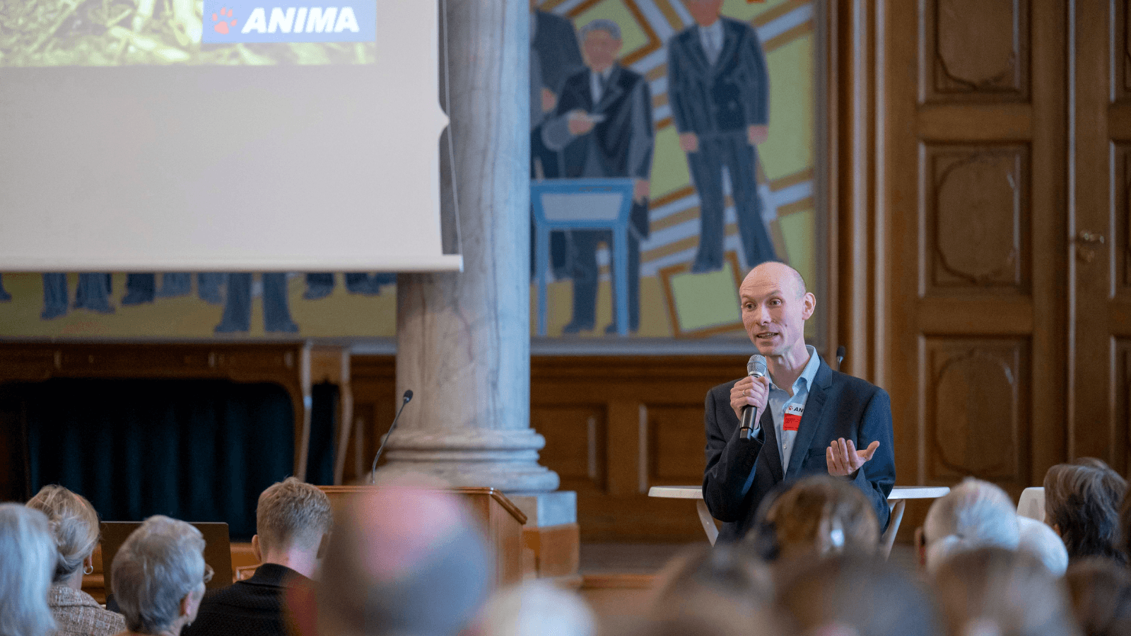 Joh Vinding, direktør hos Anima, byder salen velkommen fra scenen